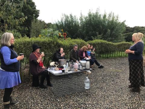 Autumn Home Medicine workshop people making herbal medicines at an outdoors medicine making station in the garden